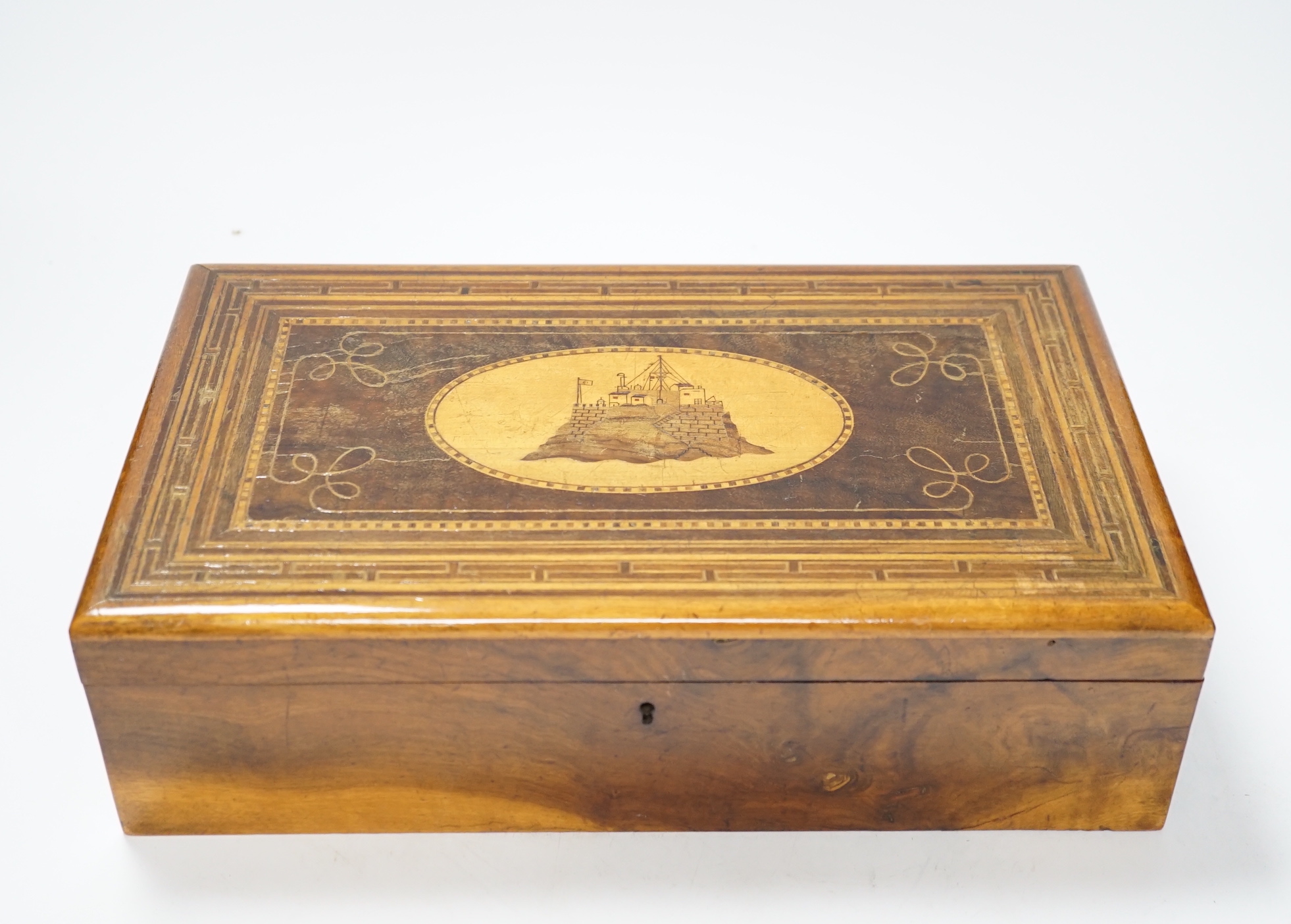 A late 19th century walnut sewing box, inlaid with a Napoleonic sea fort to a central cartouche on the lid and a fitted interior 33cm wide x10cm high